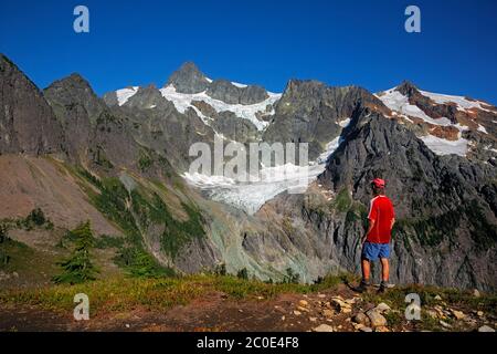 WA16693-00...WASHINGTON - Hiker su ridgecrest sopra il Lago Ann con vista del Monte Shuksan che fa parte del complesso del Parco Nazionale delle Cascate del Nord. Foto Stock