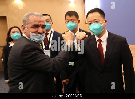 (200612) -- RAMALLAH, 12 giugno 2020 (Xinhua) -- il primo ministro palestinese Mohammad Ishtaye (L, anteriore) saluta il team di esperti medici cinesi nella città di Ramallah, in Cisgiordania, 11 giugno 2020. Un team di esperti medici cinesi, che è arrivato in Palestina mercoledì, è stato messo insieme dalla Commissione Nazionale della Sanità della Cina con i membri selezionati dalla Commissione Municipale della Sanità di Chongqing. Il team è composto da esperti di vari settori, come le malattie respiratorie e infettive, la medicina tradizionale cinese, epidemiologia e infermieristica. Hanno previsto di tenere una serie di riunioni e di v Foto Stock