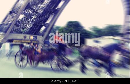 Sfondo astratto. Parigi, turisti in carrozza con cavalli vicino alla Torre Eiffel. Filtro di sfocatura applicato, con infuso vintage Foto Stock