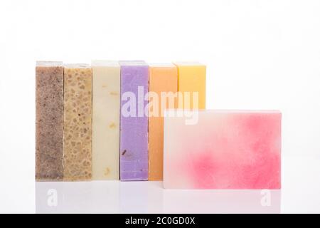 Concetto di sapone organico fatto a mano. Foto di una fila di saponette colorate e fatte in casa isolate su sfondo bianco Foto Stock