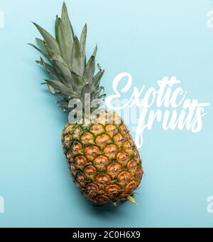 vista dall'alto dell'intero ananas tropicale maturo su sfondo blu con illustrazione di frutta esotica Foto Stock