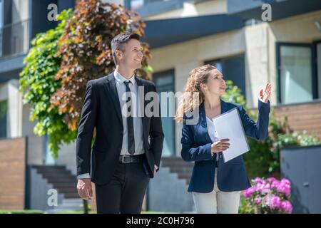 Broker femminile che mostra case con appartamenti in affitto al cliente Foto Stock