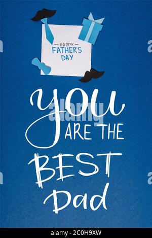 vista dall'alto del biglietto di auguri con lettere giorno felice dei padri e carta artigianato elementi creativi decorazione su sfondo blu, siete il migliore papà illus Foto Stock