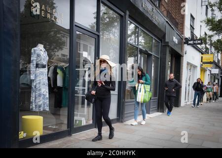 I visitatori di Kings Road a Chelsea, West London camminano per le strade vuote mentre i negozi si preparano ad aprire le porte ai clienti lunedì 15 giugno, dopo l'introduzione di misure per far uscire l'Inghilterra dalla zona di blocco. I rivenditori si stanno preparando alla riapertura di negozi che sono stati autorizzati a commerciare online solo dall'inizio del blocco di marzo. Foto Stock