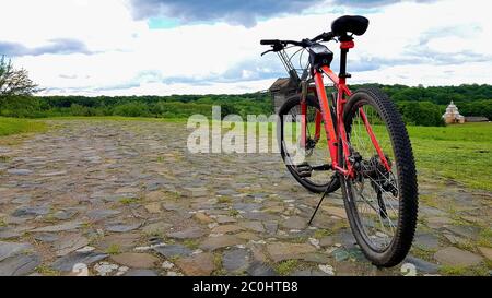 Ucraina, Kiev - 11 giugno 2020. Bella estate naturale paesaggio immagine con una mountain bike rosso si erge su una strada rocciosa Foto Stock