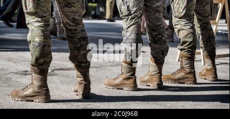 Primo piano di soldati in fila. Dettaglio di stivali militari e uniformi camouflage. Foto Stock