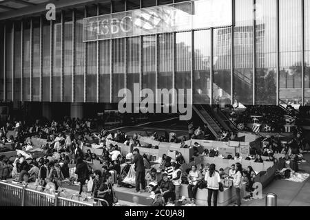 Poveri senza tetto immigrati clandestini sopravvissuti in cartonboard di fronte alla ricca banca HSBC a Hong Kong Foto Stock