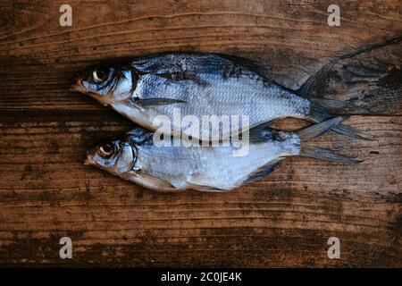 Pesce di fiume secco salato su sfondo di legno scuro. Pesce secco nel mercato. Cibo di strada. Foto Stock