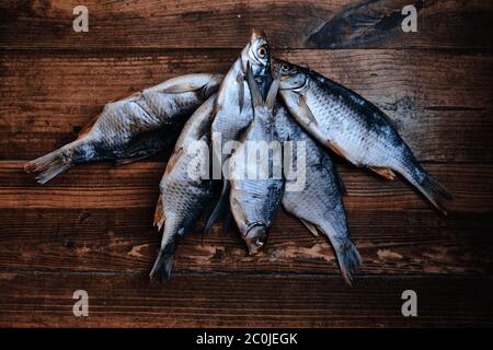 Pesce di fiume secco salato su sfondo di legno scuro. Pesce secco nel mercato. Cibo di strada. Foto Stock