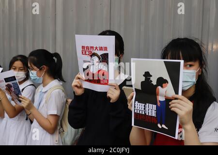 Hong Kong, CINA. 12 giugno 2020. Le studentesse di HEUNG ALLA SCUOLA MEDIA, una scuola tradizionale pro-Pechino 'sinistra', che mostra un poster al di fuori della facoltà, sul poster è scritto: PURGE OVER HONG KONG ACADEMY, SECONDA RIVOLUZIONE CULTURALE, CATASTRAOPHE ERA TORNATO, NON C'È SPAZIO PER RITIRARSI. 12 Giugno 2020 Hong Kong.ZUMA/Liau Chung-ren Credit: Liau Chung-ren/ZUMA Wire/Alamy Live News Foto Stock