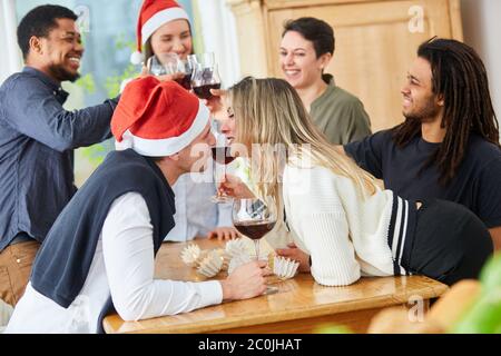 Due colleghi baciano in un party di Natale in ufficio prima di Natale Foto Stock