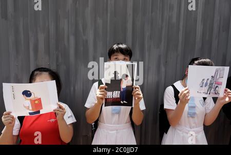 Hong Kong, CINA. 12 giugno 2020. Le studentesse mostrano un piccolo poster fuori HEUNG ALLA SCUOLA MEDIA, una scuola tradizionalmente pro-Pechino 'sinistra', il poster al centro è scritto NON TEME CONTRO IL TERRORISMO FASCISMO.Giugno-12, 2020 Hong Kong.ZUMA/Liau Chung-ren Credit: Liau Chung-ren/ZUMA Wire/Alamy Live News Foto Stock