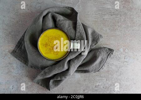 Tazza d'autunno accogliente con latte curcuma dorato Foto Stock