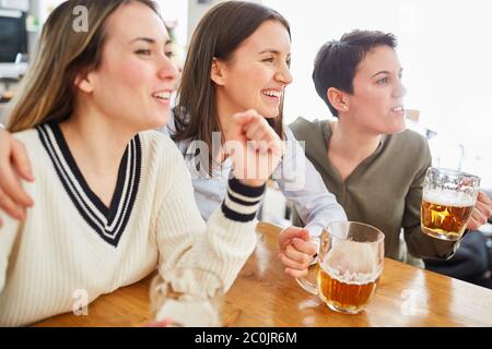 Gruppo di donne guarda il calcio, beve birra e brilla nella loro squadra Foto Stock