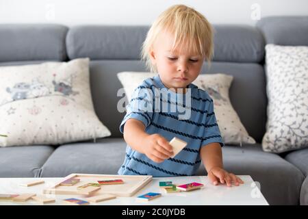 Piccolo bambino che fa puzzle. Ragazzo imparare di base sviluppare le abilità cognitive, concetto di bambino Foto Stock