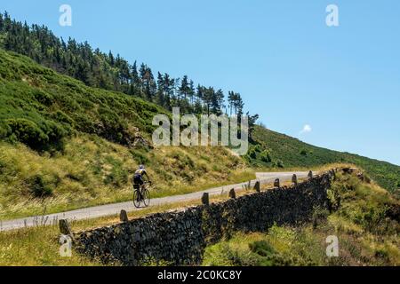 Ciclista su una strada a Cévennes Gardoises. Sito patrimonio dell'umanità dell'UNESCO. Parco Nazionale delle Cévennes. Gard . Occitanie. Francia Foto Stock