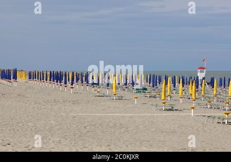 spiaggia deserta con pochissime persone e ombrelloni chiusi a causa della terribile crisi economica causata dalla pandemia del coronavirus Foto Stock