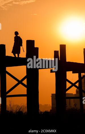 Ragazza di U Bein bridge al tramonto, lago Taungthaman, Amarapura, Birmania. Foto Stock