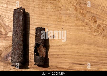 vecchia conchiglia arrugginita di artiglieria e proiettile di aerei su sfondo di legno, vecchie conchiglie arrugginite trovati proiettili della guerra mondiale 2, scavati fuori dal suolo Foto Stock