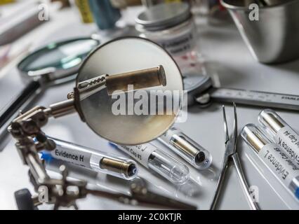 Polizia scientifica esaminando un proiettile cap in laboratorio balistico, immagine concettuale Foto Stock