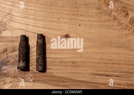 vecchia conchiglia arrugginita di artiglieria e proiettile di aerei su sfondo di legno, vecchie conchiglie arrugginite trovati proiettili della guerra mondiale 2, scavati fuori dal suolo Foto Stock