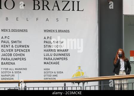 Una donna all'ingresso del centro commerciale Victoria Square, Belfast, dopo che tutti i centri commerciali e i rivenditori sono stati dati il via libera per riaprire in un significativo rilassamento delle restrizioni di blocco del coronavirus nell'Irlanda del Nord. Foto Stock