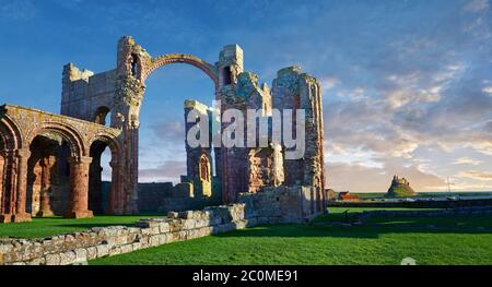 Le rovine romaniche dell'abbazia di Lindisfarne, sassone, che si affaccia sul castello di Lidisfarne, sull'isola Santa, su Lindisfarne, su Northumbria, in Inghilterra Foto Stock