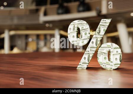 Segno di percento fatto dalle fatture del dollaro sulla tabella di legno nel deposito di reparto. Concetto di offerta speciale Foto Stock