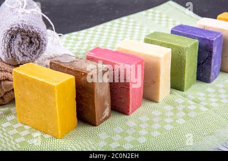 Saponi organici fatti a mano. Vari tipi di sapone naturale fatto a mano sul tavolo, sapone naturale di forme e colori diversi, immagini dall'alto. Foto Stock