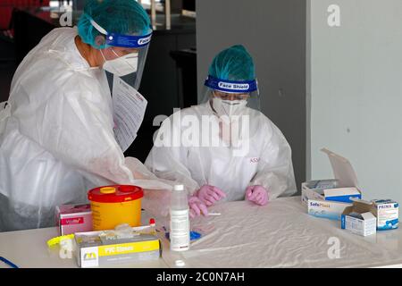 Bucarest, Romania. 10 Giugno 2020. Gli operatori sanitari aspettano che le persone siano sottoposte a test per la ricerca di anticorpi COVID-19 presso un centro di test nello stadio di calcio della National Arena di Bucarest, Romania, 10 giugno 2020. Il primo ministro rumeno Ludovic Orban ha annunciato a fine giovedì un nuovo ciclo di relax delle restrizioni COVID-19, tra cui la riapertura di centri commerciali, sale da gioco e piscine all'aperto a partire da giugno 15. Credit: Cristian Cristel/Xinhua/Alamy Live News Foto Stock