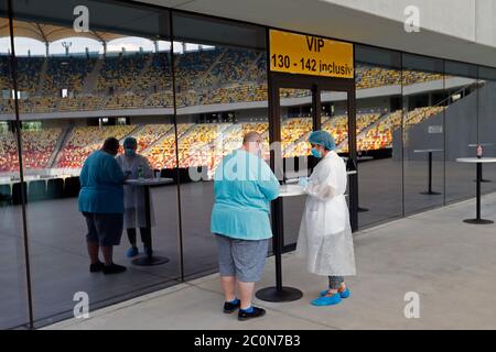 Bucarest, Romania. 10 Giugno 2020. Un medico parla con un uomo da testare per gli anticorpi COVID-19 in un centro di test nello stadio di calcio della National Arena di Bucarest, Romania, 10 giugno 2020. Il primo ministro rumeno Ludovic Orban ha annunciato a fine giovedì un nuovo ciclo di relax delle restrizioni COVID-19, tra cui la riapertura di centri commerciali, sale da gioco e piscine all'aperto a partire da giugno 15. Credit: Cristian Cristel/Xinhua/Alamy Live News Foto Stock