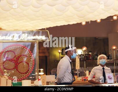 Parigi, Francia. 15 maggio 2020. I membri del personale indossano maschere e visiere in un famoso negozio di macaron presso gli Champs Elysees Avenue a Parigi, Francia, il 15 maggio 2020. La Francia ha visto la distruzione netta di mezzo milione di posti di lavoro sui salari nel primo trimestre 2020, soprattutto in occupazione temporanea, ha detto giovedì l'ufficio nazionale per le statistiche INSEE. Credit: Gao Jing/Xinhua/Alamy Live News Foto Stock