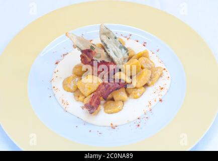 Gnocchi con burro di zucca e arachidi e pancetta croccante Foto Stock