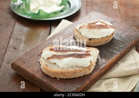 Bruschetta italiana con pane calabrese, burrata e acciughe Foto Stock