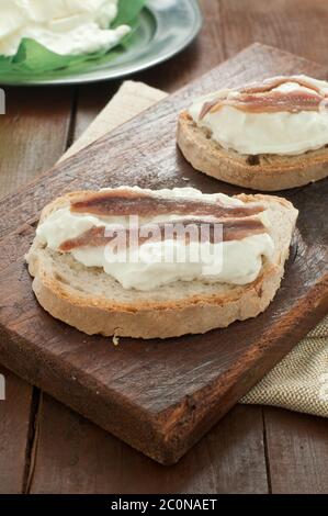 Bruschetta italiana con pane calabrese, burrata e acciughe Foto Stock