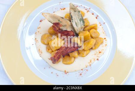 Gnocchi con burro di zucca e arachidi e pancetta croccante Foto Stock