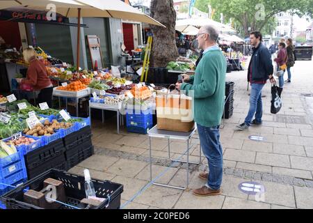 Misure di distanziamento sociale in funzione sul mercato di Norwich durante il blocco di Coronavirus, Regno Unito, giugno 2020. Frutta e verdura stalla Foto Stock