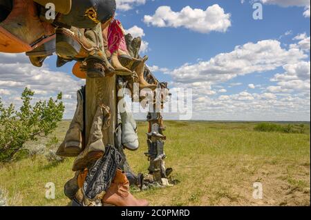 Vecchi stivali da cowboy appesi su una rotaia di legno a Great Sandhills vicino alla città di leader, Saskatchewan, Canada Foto Stock