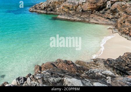 ACHMELVICH BAY E BEACH SUTHERLAND HIGHLANDS SCOTLAND UNA PICCOLA COVE CON I COLORI DEL MARE E LE ROCCE DI COLORE ARANCIO Foto Stock