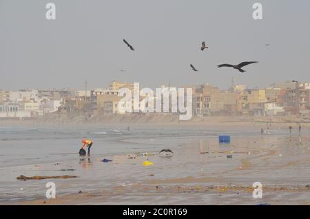 Aquiloni neri che volano sulla spiaggia di Yoff, un sito di sbarco artigianale per la pesca e popoloso quartiere costiero di Dakar, Senegal Foto Stock