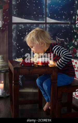 Dolce bambino, ragazzo, mangiando gli spaghetti a casa a Natale Foto Stock