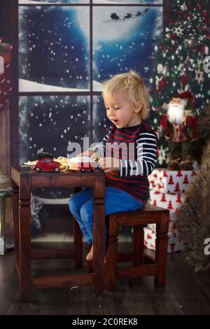 Dolce bambino, ragazzo, mangiando gli spaghetti a casa a Natale Foto Stock