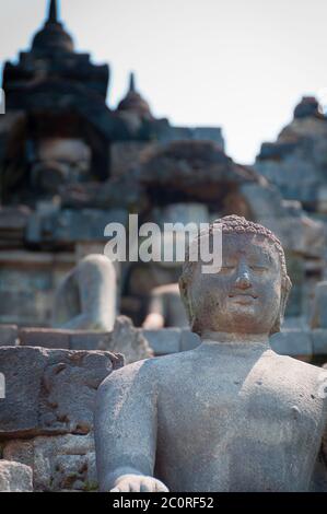 Seduta e sorridente Buddha in pietra a Borobudur Foto Stock