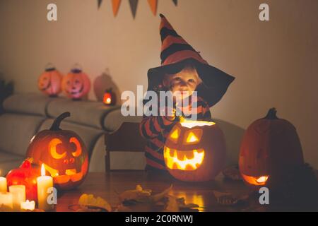 Bambini, fratelli ragazzi, giocando con zucca scolpita a casa su Halloween, facendo pozione magica Foto Stock