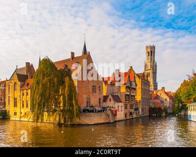 La città di Bruges, Fiandre, in Belgio. Canale d'acqua in corrispondenza di Rozenhoedkaai con vecchi edifici in mattoni e la torre campanaria in background. Foto Stock