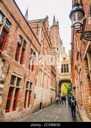 Ponte che attraversa gli edifici sulla stretta Blinde-Ezelstraat, nota anche come Blind asey Street, vicino a Burg Square, Bruges, Belgio. Foto Stock