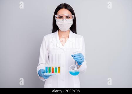 Ritratto di lei bella lei sicuro attraente biologo esperto ragazza qualificata che tiene in mani colorful fiasca epidemia pandemia invenzione isolato Foto Stock