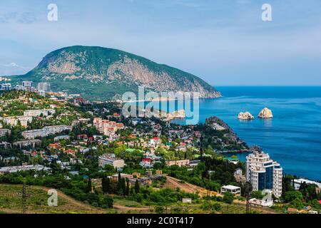 Vista panoramica sulla città Gurzuf e Bear Mountain, Au-Dag, Crimea. Giorno di sole. Il concetto di città attiva in unità con la natura. Foto Stock