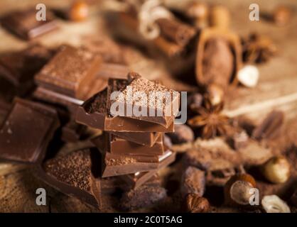 Pezzetti di cioccolato su sfondo di legno Foto Stock