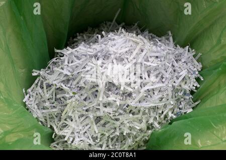 Un dettaglio di documenti nazionali e documenti cartacei triturato in un bidone di carta straccia rivestito di una borsa di polietilene verde, una precauzione contro il furto di identità e per garantire la protezione dei propri dati personali dalle frodi, il 12 giugno 2020, a Londra, Inghilterra. Foto Stock